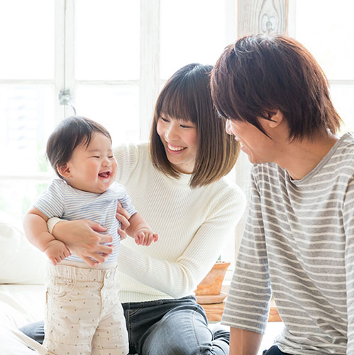 family smiling with baby